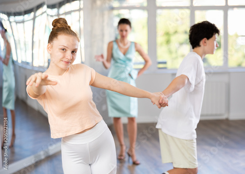 Tableau sur toile Smiling teenage girl practicing vigorous jitterbug moves with partner during dan
