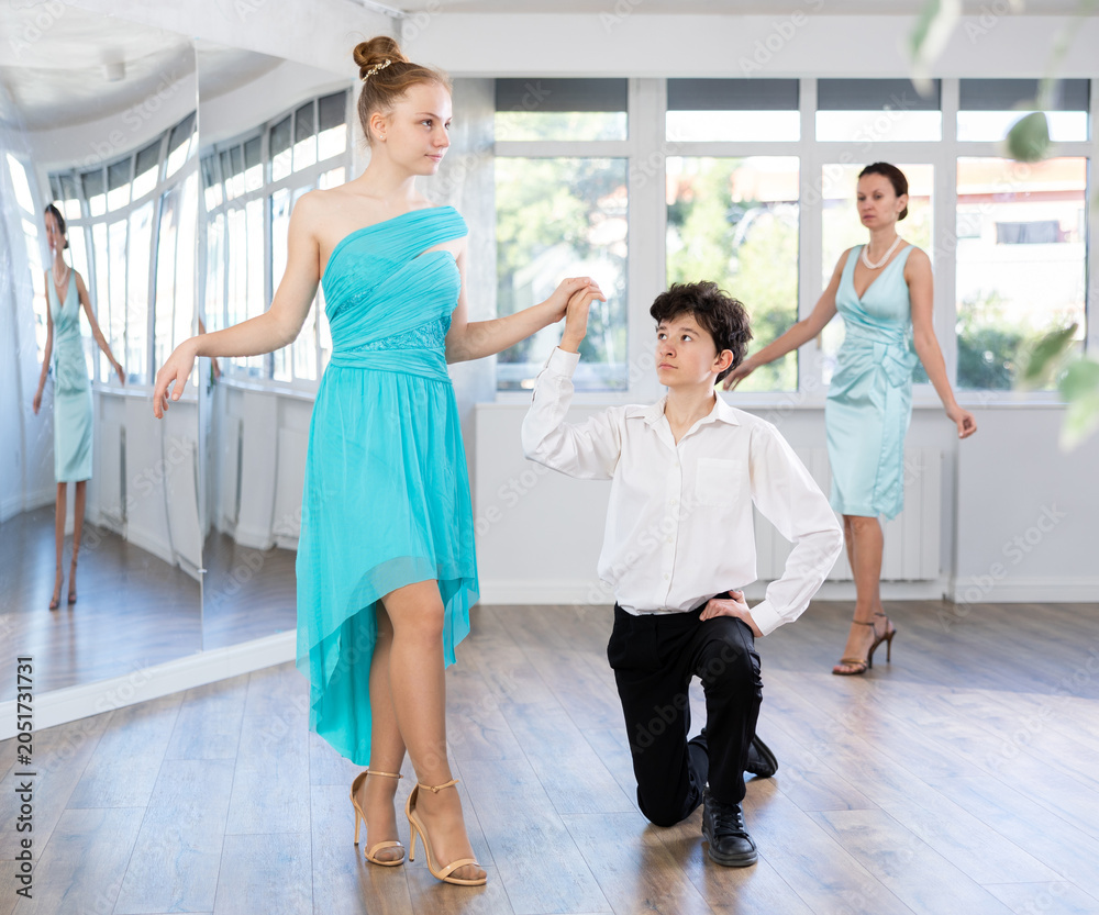 Fototapeta premium Young of teenagers in evening dresses are learning to dance an polonaise dance