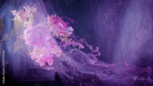 Abstract wisps of pink and purple smoke drift across a dark background, with soft glowing haze and fluid motion spreading from left to right in a moody