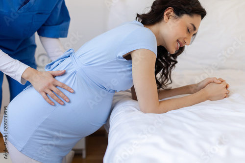 Photography Pregnant woman practicing labor positioning with support from nurse during prena