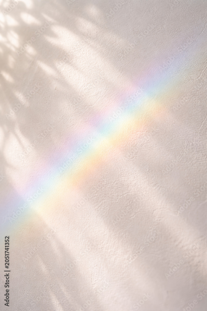 Naklejka premium Soft pastel rainbow reflecting on a textured white wall