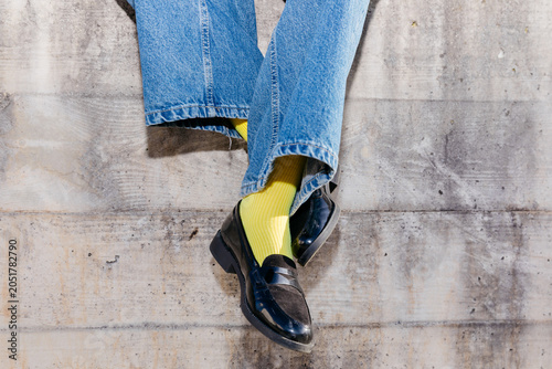 Person wearing jeans, yellow socks, and loafers