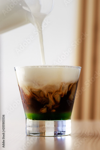 Pouring Milk Into Iced Coffee Glass