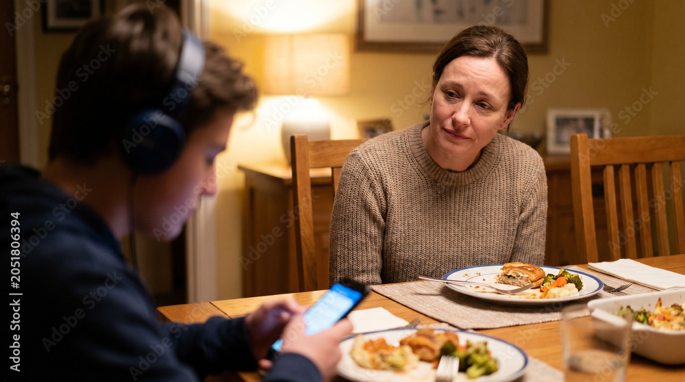 Fototapeta premium Worried mother looking at distracted son during dinner