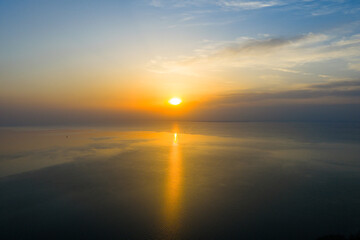 Golden sunset over calm lake with tree silhouettes on shoreline