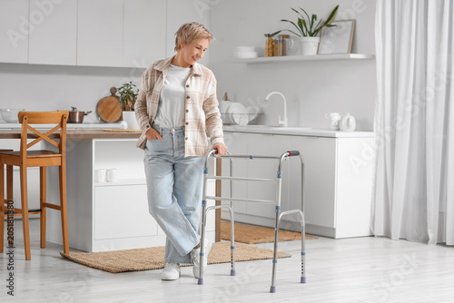 Mature woman with walker in kitchen