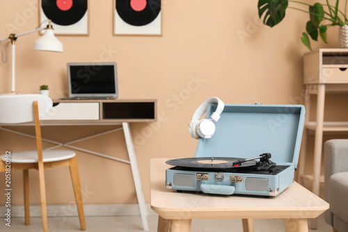 Retro record player with headphones and vinyl disk on coffee table in living ...