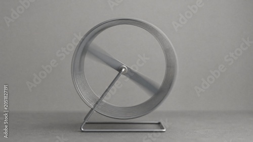 antecedence. Hamster wheel in endless rotation on a plain grey background. wildlife magazines, conservation campaigns, designed for nature documentaries and education, used by health educators.