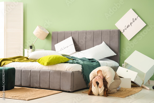 Woman hiding near bed durin...