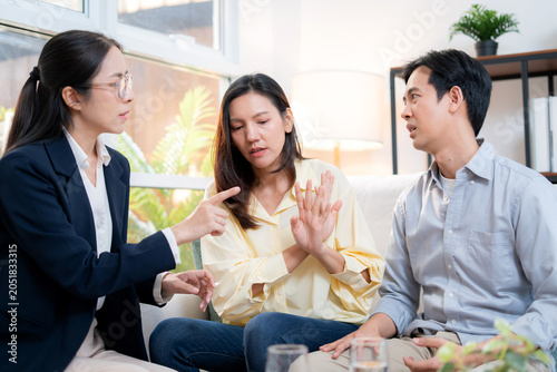Asian couple arguing with therapist during home consultation, frustrated wife talking to psychologist, stressed husband to relationship disagreement, psychological stress causing anxiety and problem.