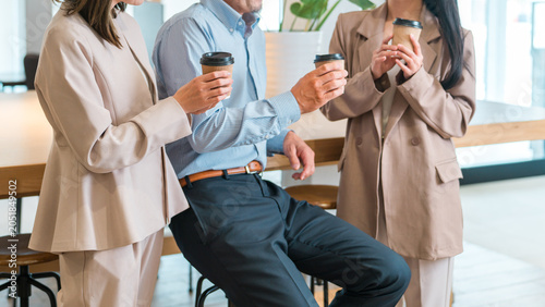 Bild auf Leinwand Businessmen and businesswomen chatting while drinking coffee in the office