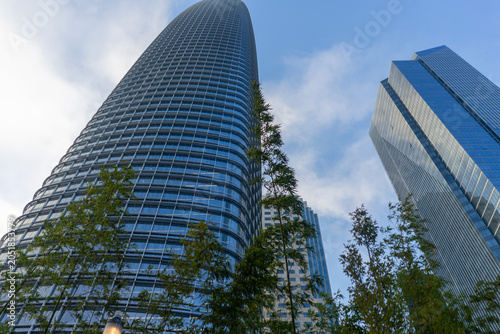 Fotografie Surrounding modern skyscrapers rising high into a cloudy sky, showcasing contemp