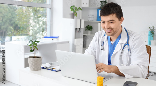 Male doctor working on laptop in  clinic