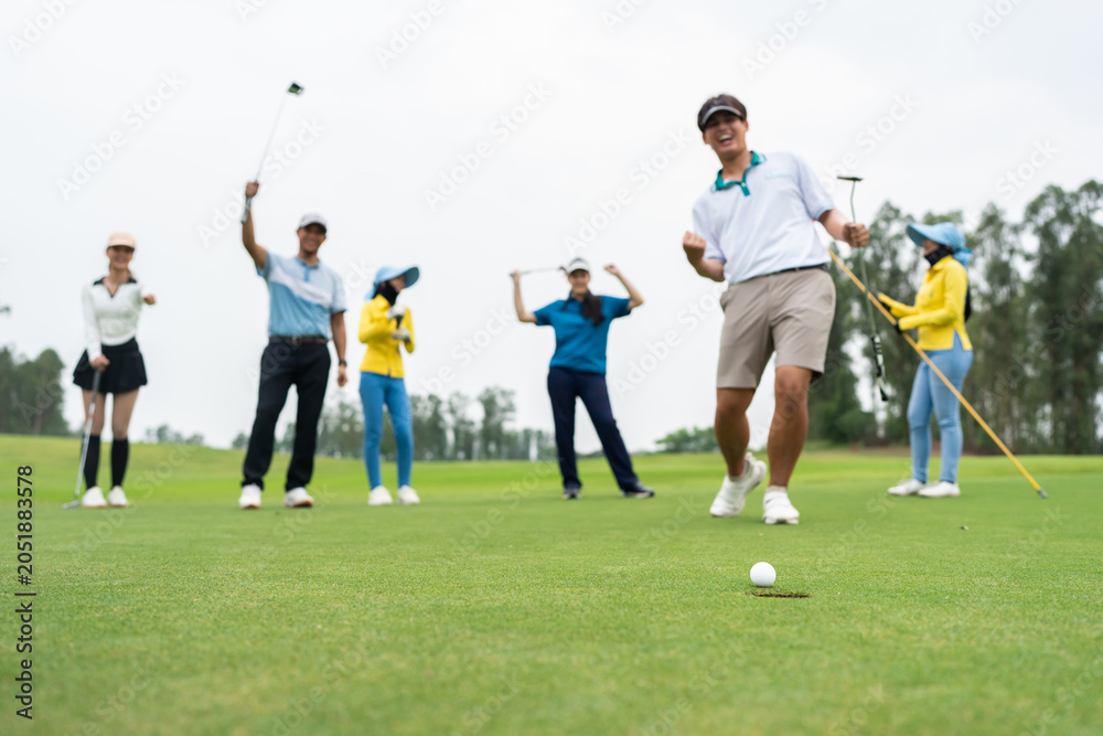Naklejka premium Group of young pro golfers swings their club on scenic golf course. 