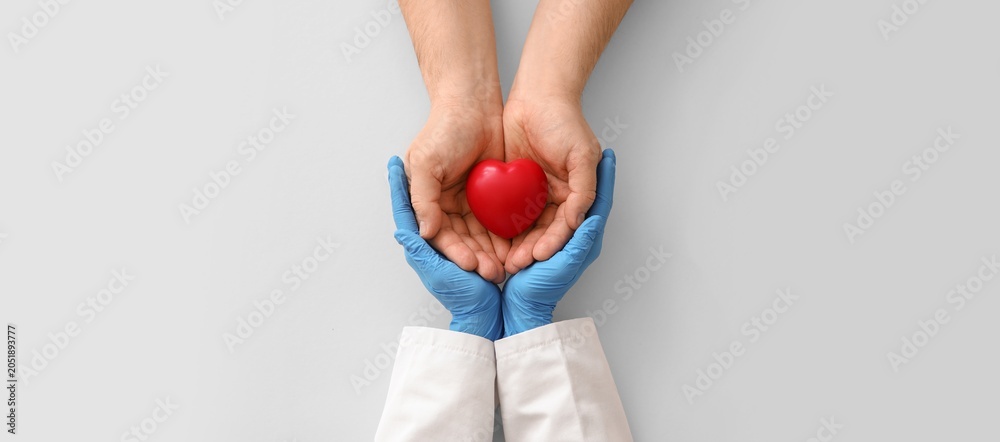 Naklejka premium Doctor and patient hands holding red heart, medical care, health insurance, cardiology, and organ donation