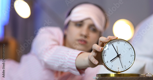Young woman turning off ala...