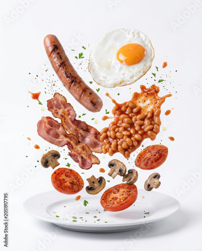 Traditional English breakfast ingredients levitating above a white ceramic plate