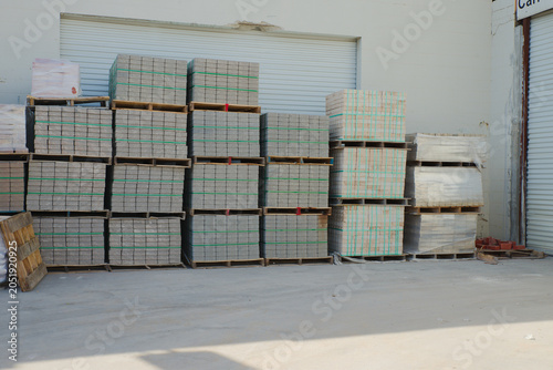 Obraz na plátně Neatly stacked pale bricks secured with green strapping on a wooden pallet at a
