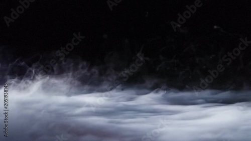 Heavy Smoke and Low Fog Rolling on Ground Over Black Background Loop