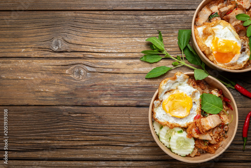 Thai street food, Pad Kra Pao Moo Krob or stir-fried crispy pork with holy basil and fried egg on rice, popular Asian spicy meal.