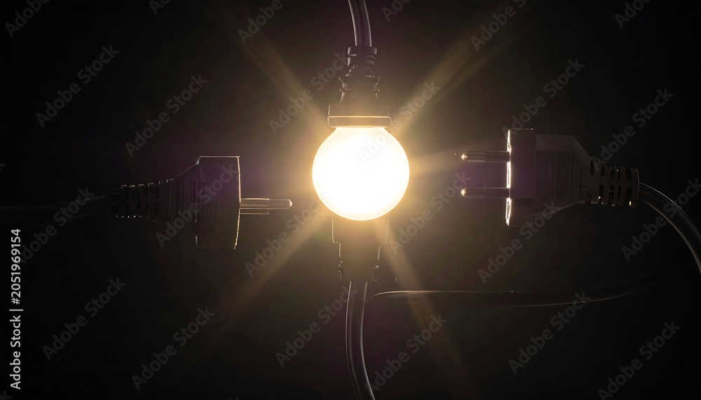 Fototapeta premium Glowing bulb between plugs, radiating bright light against a black backdrop. Cables entwine, suggesting electricity