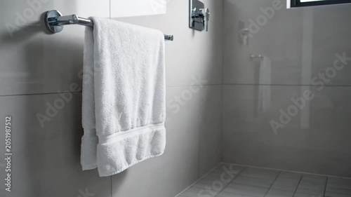 Clean white towel hanging on a chrome rack in a modern bathroom.