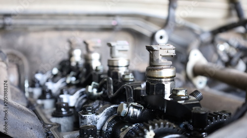Engine fuel injector. Close-up of dirty fuel injector of common rail diesel engine under maintenance with copy space with selective focus.