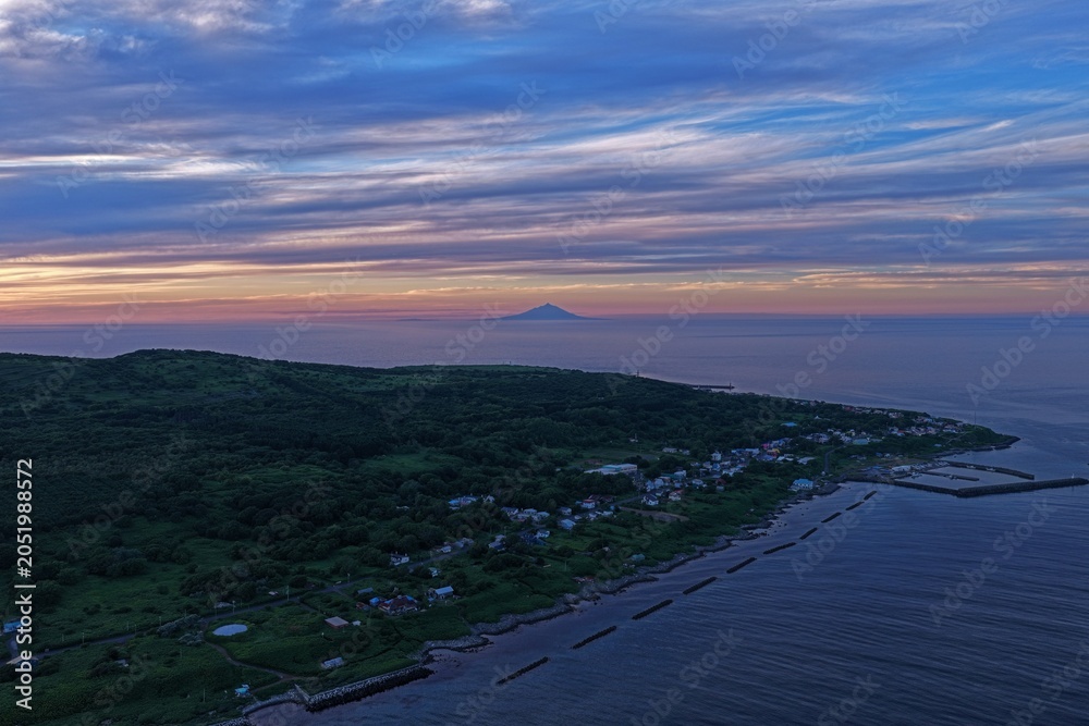 Obraz premium Aerial drone photo of coastal village and distant mountain at dusk, Teuri Island, Hokkaido, Japan