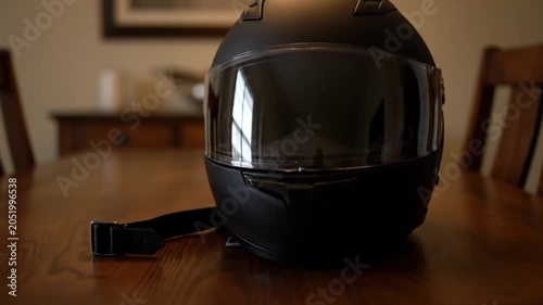 Black Matte Full Face Motorcycle Helmet Resting on a Wooden Table.