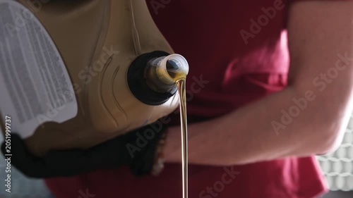 Mechanic With A Pouring Motor Oil From Canister