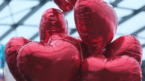Red Heart-Shaped Balloons Tied To Strings Flying In The Shopping Mall
