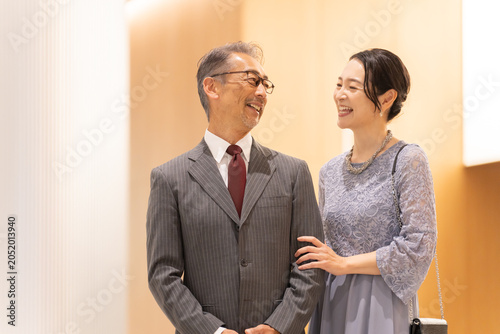 Canvastavla ホールの前に立つフォーマルな中高年夫婦