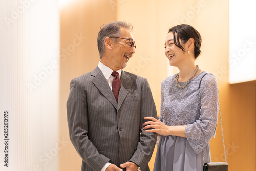 Konstfotografi ホールの前に立つフォーマルな中高年夫婦