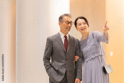 Canvastavla ホールの前に立つフォーマルな中高年夫婦