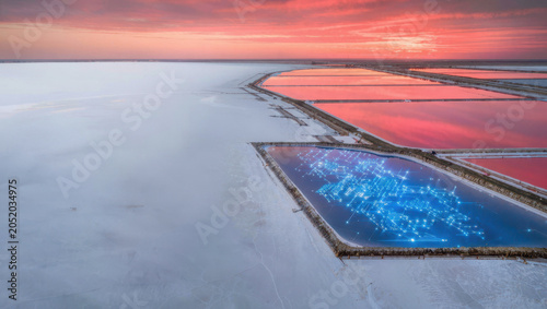 Salt pond sunset aerial, pink sky reflection, blue basin, geometric landscape, coastal salt flat