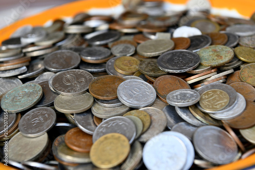 Fotografía A close-up, shallow depth of field shot of a large pile of old vintage coins, including various denominations of Cypriot mils, shillings, and international currency collected together