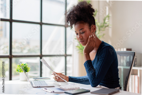 Foto Woman carefully analyzing documents and financial data, calculating budget numbe