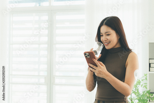 Woman Checking Blood Glucose Level During Telehealth Consultation at Home