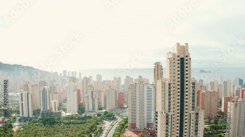 Panoramic city view of Benidorm modern skyline with high-rise hotels, beachside resorts, and the sparkling Mediterranean Sea. Popular tourist destination in the Alicante region of Spain.