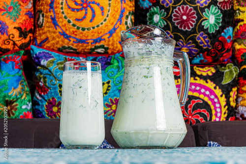 Tableau sur toile Refreshing buttermilk served in a colorful setting with vibrant cushions and int
