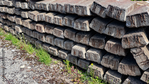Foto Numerous old concrete railway sleepers, featuring exposed rebar and weathered su