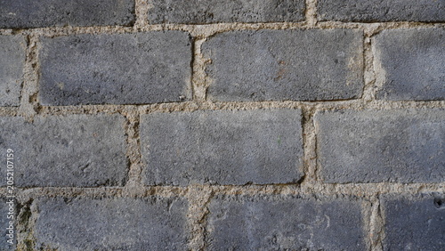 Close-up of a cement wall surface featuring rough texture, subtle imperfections, and natural construction patterns. The minimalist composition highlights the material's raw appearance, making it ideal