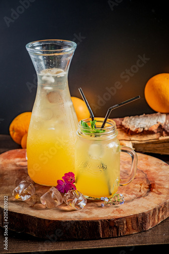 Photos Refreshing citrus drink served in a mason jar with ice and vibrant oranges in th
