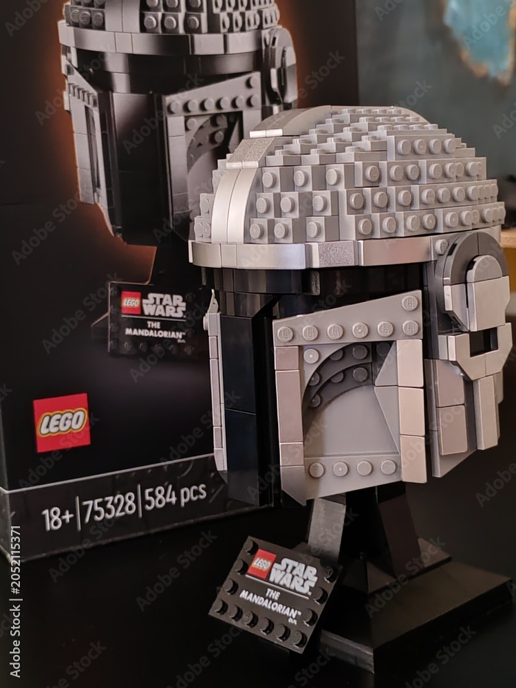 Fototapeta premium Rome, Italy - June 10, 2026, Mandalorian helmet from the Star Wars series with the box next to it, produced by Lego, inside a toy store.