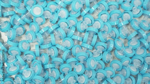 Laboratory technician handling blue PTFE syringe filters for sample purification before HPLC and LC analysis. Scientific research environment, chromatography sample preparation, analytical chemistry