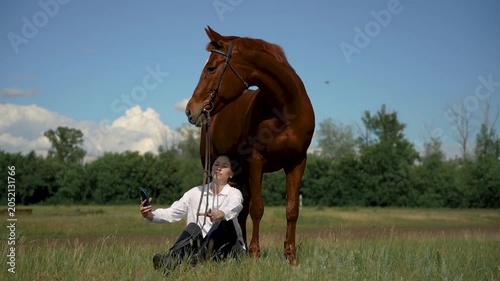Young woman and horse in a field, blue sky