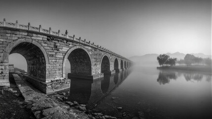 B&W panorama of Lugou Bridge over misty river at dawn. Soft light, silky reflections, and ancient stone lions evoke solemn heritage. Perfect for tourism campaigns with negative copy space.
