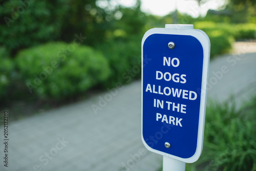 Fotografie Blue sign says no dogs allowed in park with copy space