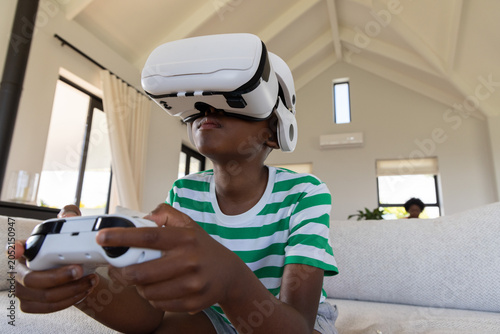 Photography African American family watching boy holding white game controller and wearing V