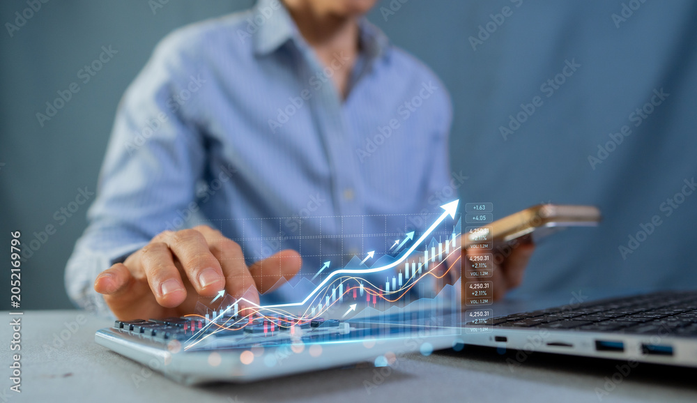 Fototapeta premium Businessman using laptop and smartphone with growing stock market graph for financial investment